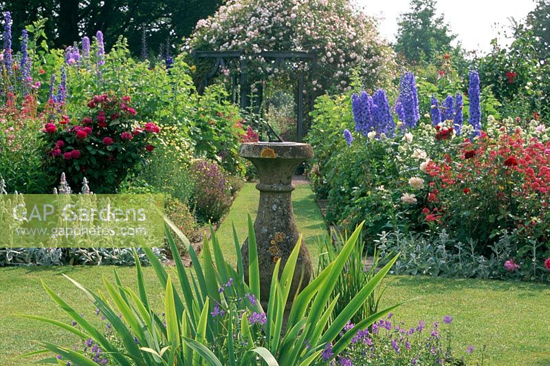 Sundial as focal point in formal flower garden at Wollerton Hall in Shropshire. 