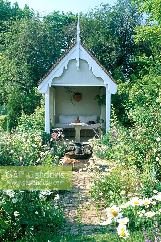 Decorative summerhouse in informal setting with Ox eye daisies at Park Farm in Essex
