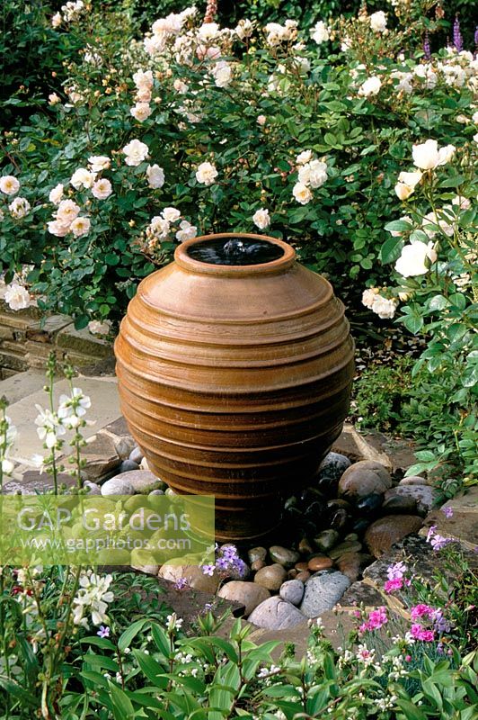 Small bubble fountain made from re-used terracotta container with Rosa 'Penelope' - Pondfield Cottage, Sussex