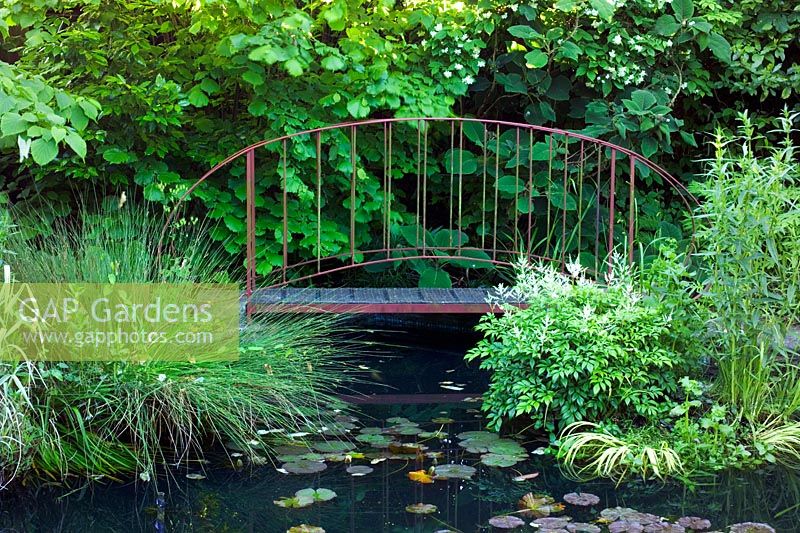 Bridge over pond converted from old swimming pool at Brewery House in Somerset