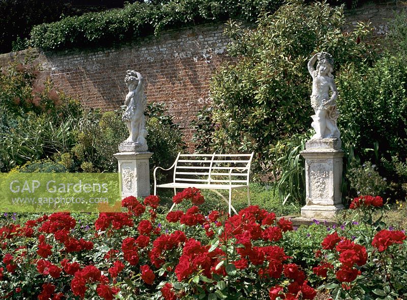 Rose garden with sculptures either side of bench at Polesden Lacey in Guildford, Surrey