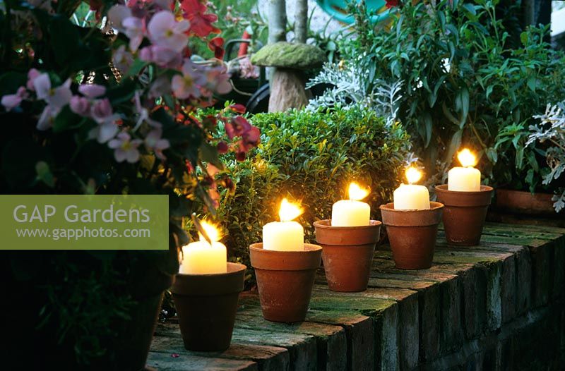 Candles in pots on garden wall