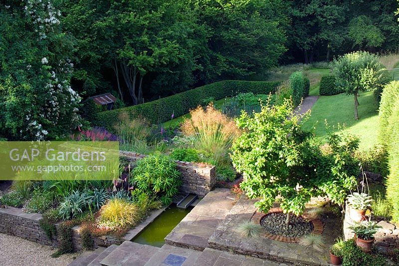 Sloping country garden in valley at Lower House, Powys in Wales