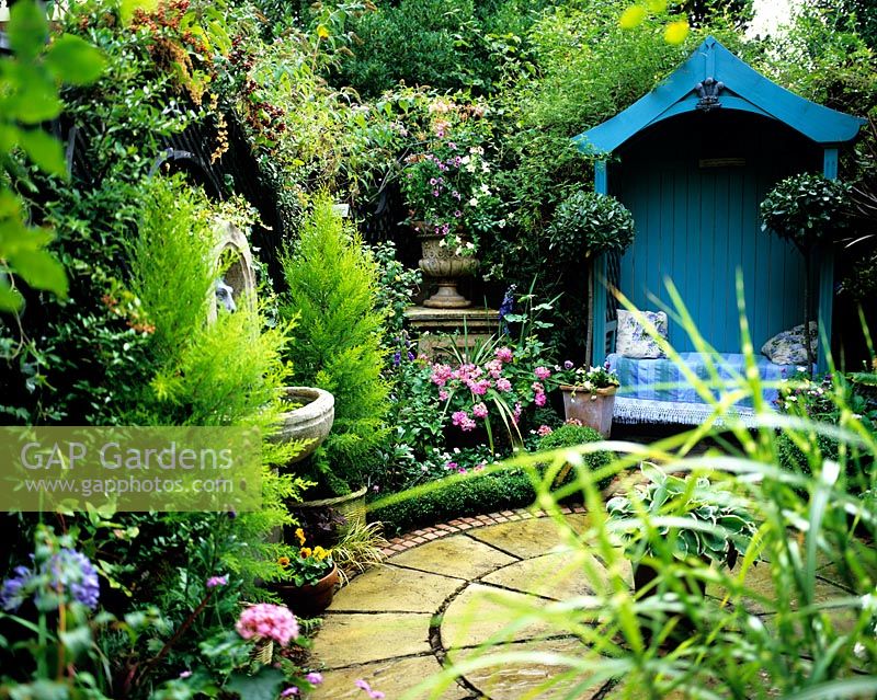 Painted blue arbour in small courtyard garden