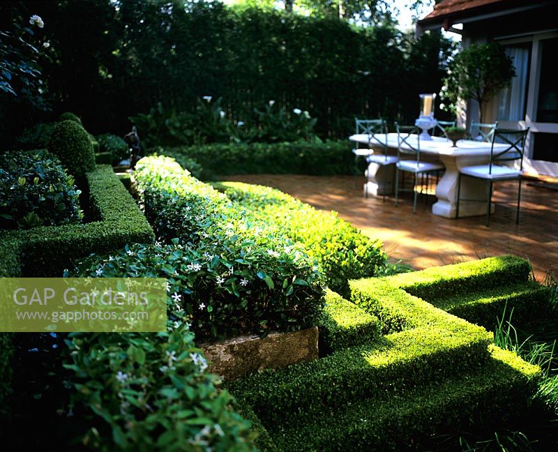 Courtyard with zig zag hedges and furniture