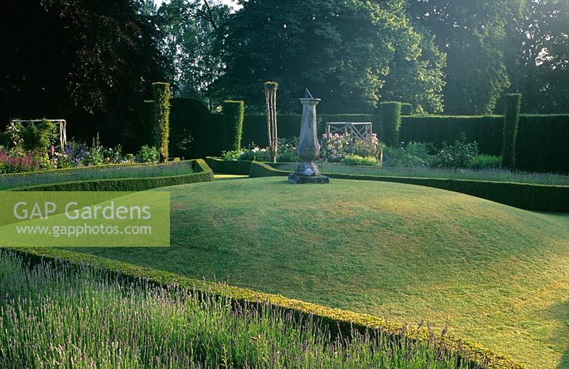 The sundial garden with mound lawn and Buxus hedges at Cranbourne Manor, Dorset