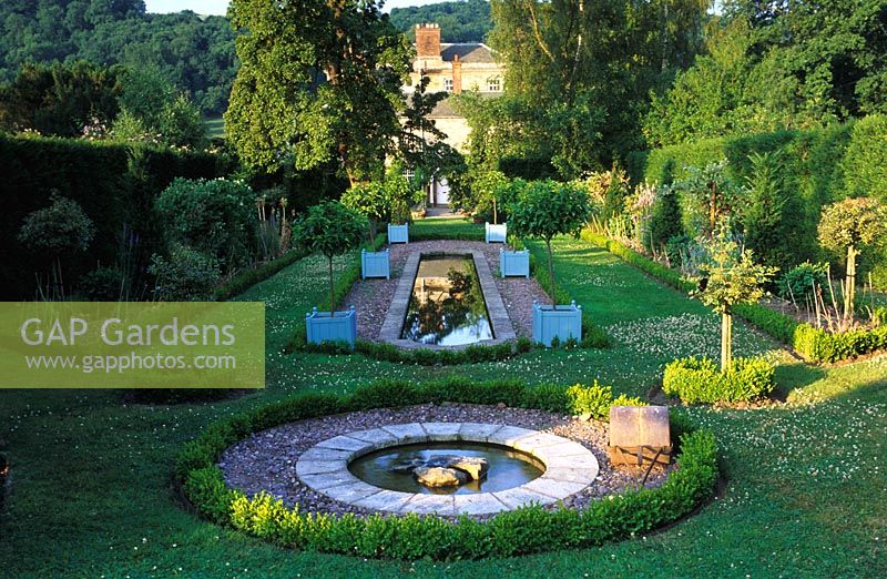 The Dower House, Shropshire. Formal water garden with rill and circular pool with view across garden to house