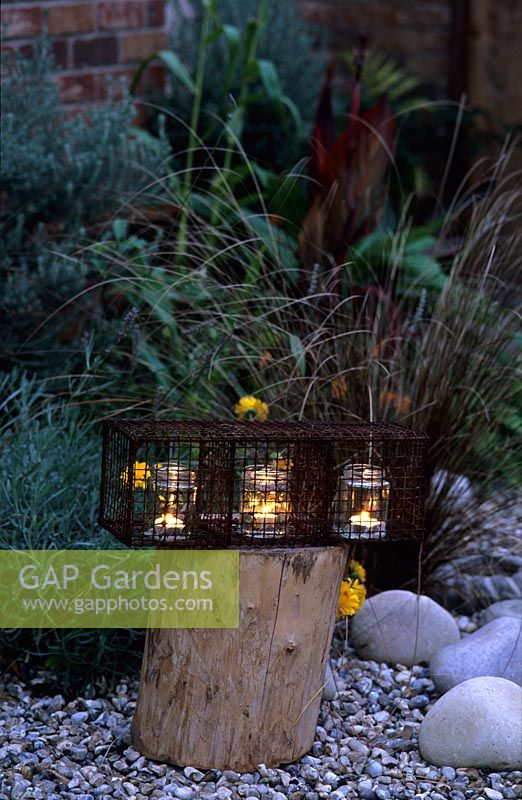 Tea light candles in wire container on log