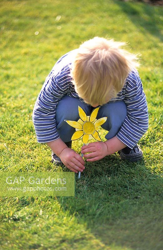 Child on lawn with cardboard daffodil