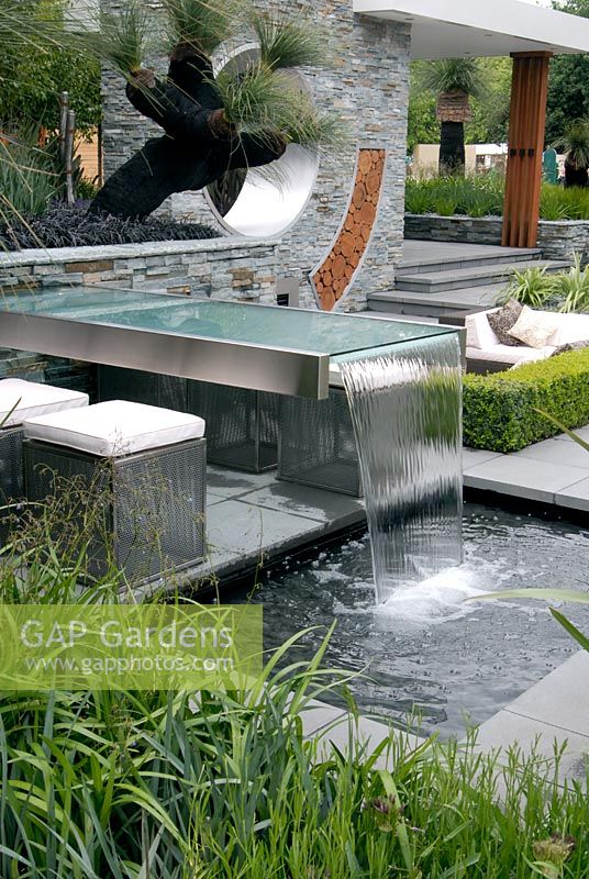 Outdoor seating area with a table water fountain and pool 