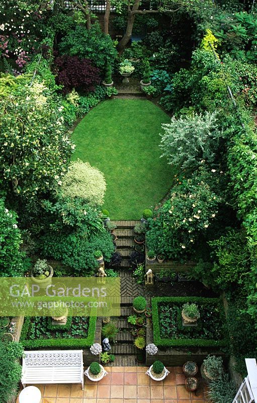 Overview of small town garden with shaped lawn and steps at Campden Hill Terrace, London. 