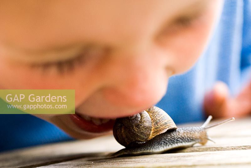 Boy pretending to eat live snail