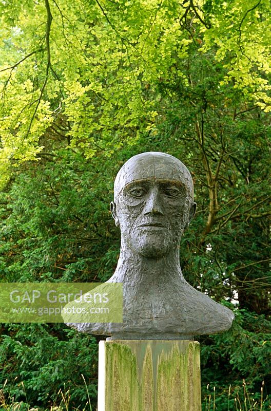 'In Memoriam III', 1983, bronze head by Dame Elizabeth Frink sited amongst trees in Cranborne Manor Garden, Cranborne, Dorset