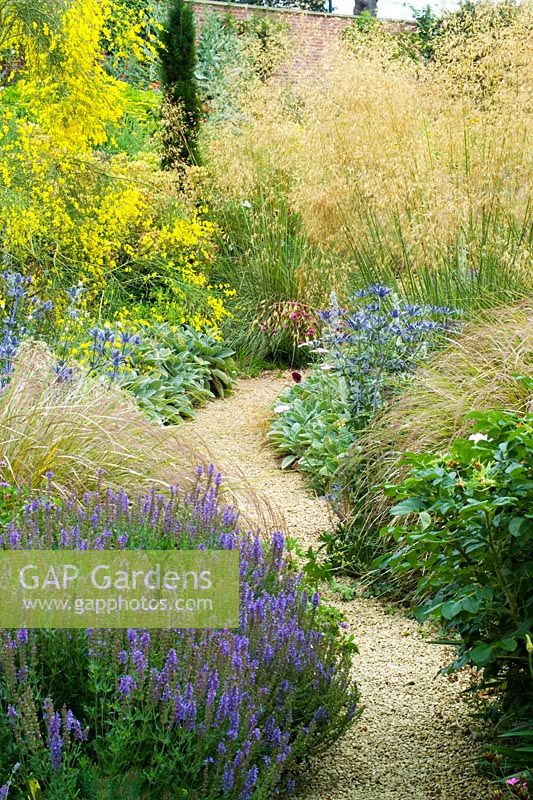 Path through borders of grasses and perennials at Broughton Grange