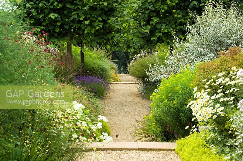 Gravel path and borders at Broughton Grange with stone urn as focal point