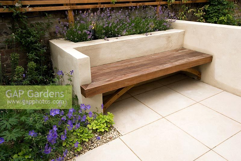Modern wooden bench set into limewashed rendered wall. Design Charlotte Rowe