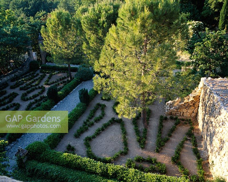 View of gravel and Buxus parterre from top of house with pine trees