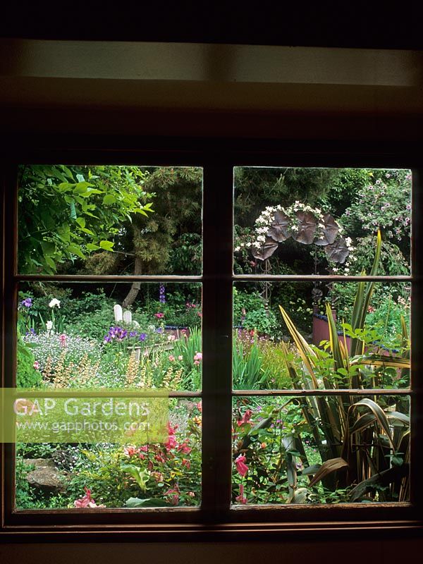 Colourful cottage style garden viewed through window at Keeyla Meadows, San Francisco, California USA