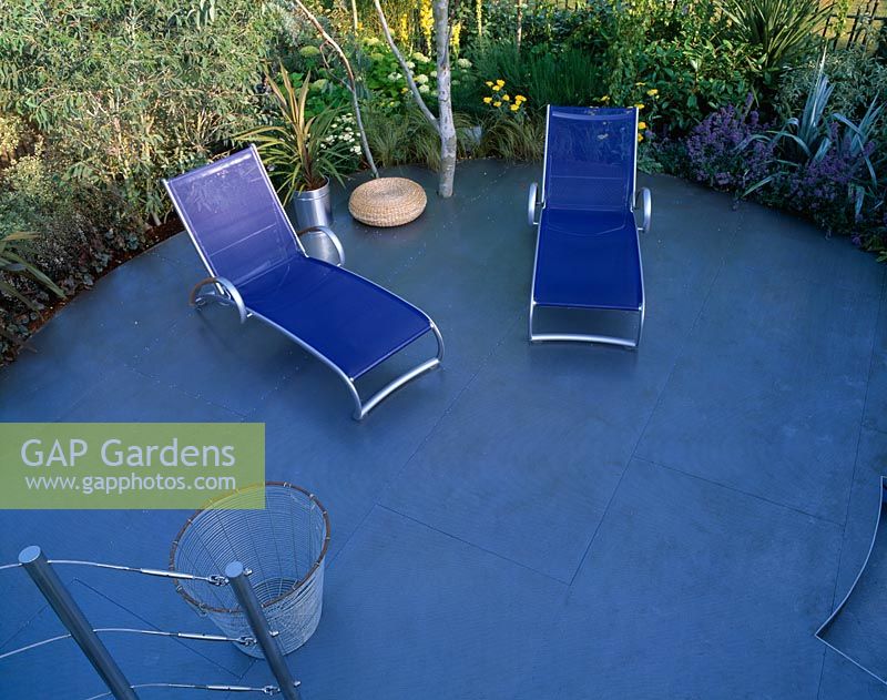 Roof deck with circular blue patio with blue sunloungers in Mercedes Benz garden at Hampton Court 2001.  