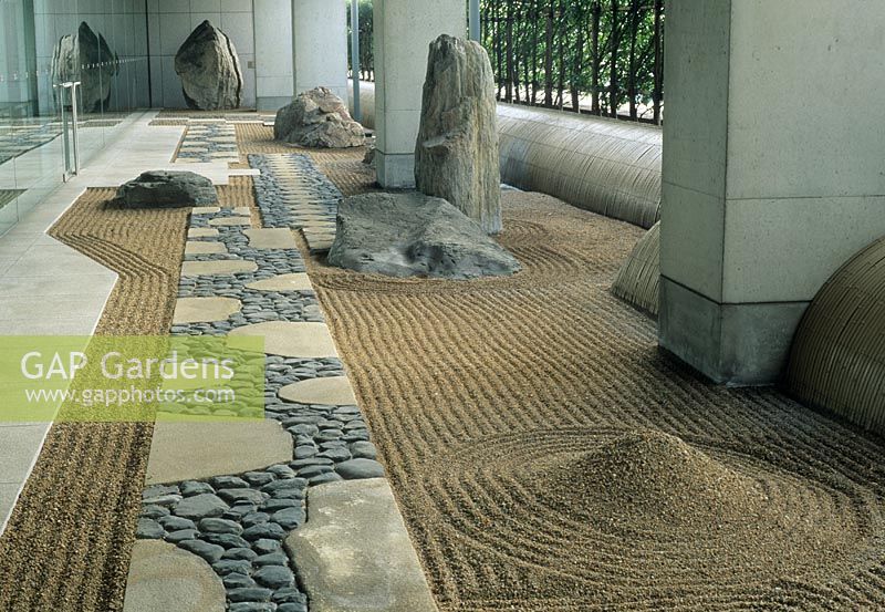 Zen style garden with rocks and raked gravel in undercroft of modern office building at The Canadian Embassy, Tokyo, Japan  