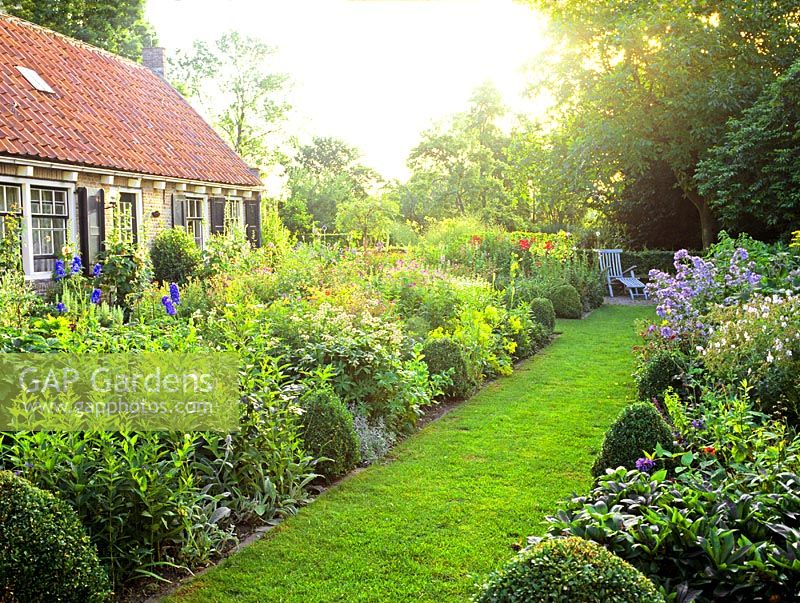 Grass path thought flowerbeds in country garden