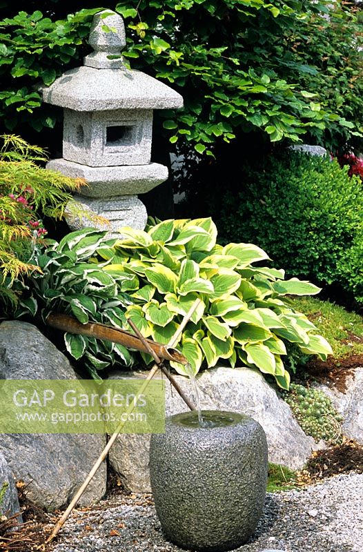 A stone water feature in an oriental garden