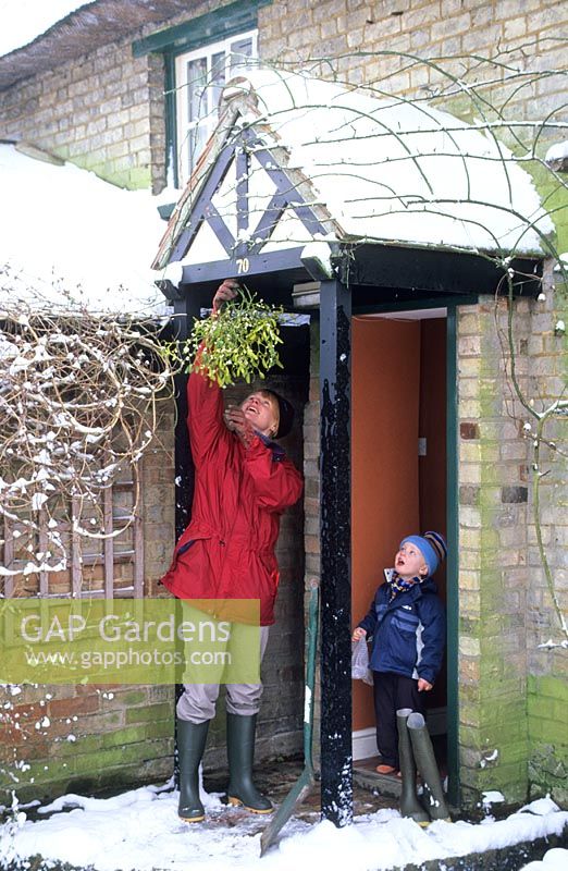 Mother and child hanging up Mistletoe