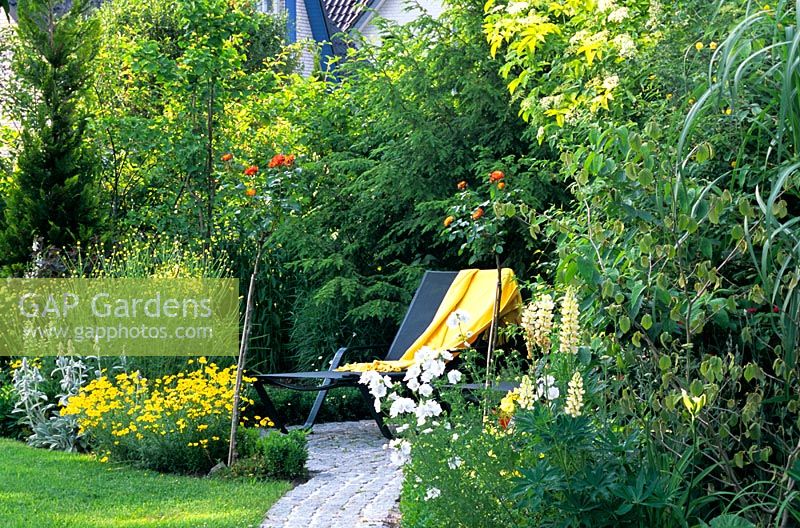 garden path leading to lounger seat with towel 