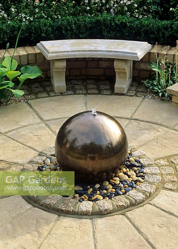 Water feature - Glazed terracotta Golden ball with pebble surround.