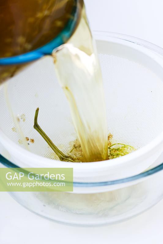 Making Elderflower cordial - Draining solution through sieve