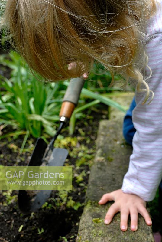 Young girl playing with a trowel