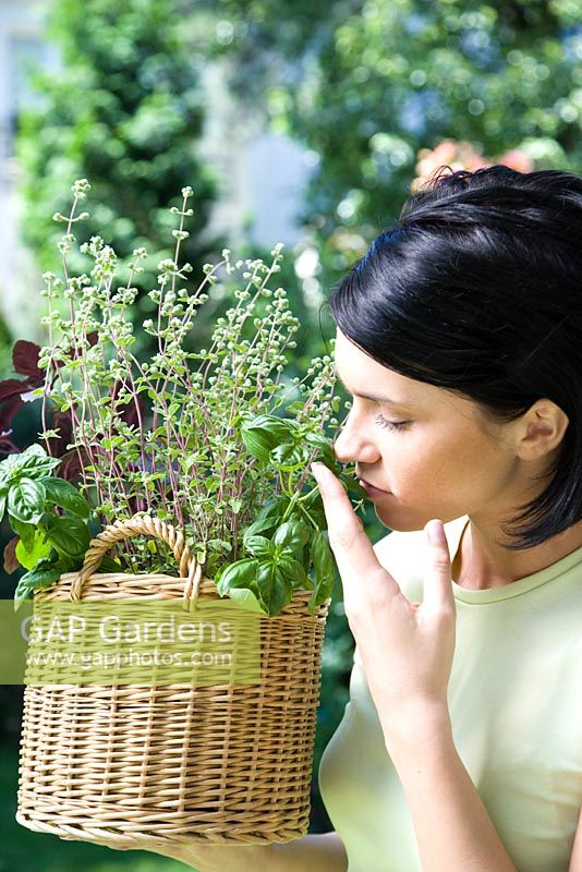 Woman smelling herbs in basket