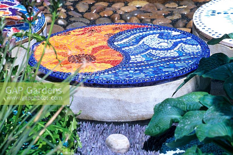 Decorative disks of glass and plastic mosaic tiles and plaster in the 'Mediterranean Chillout' garden, RHS Hampton Court Flower Show