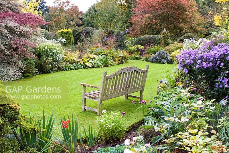 Wooden bench and borders at Eastgrove Cottage garden, Worcestershire