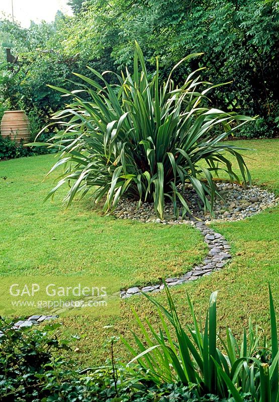 Serpentine rill divides lawn into two and leads to central cobbled area made with fossils found in the garden - Saltford Farm, Bath, UK