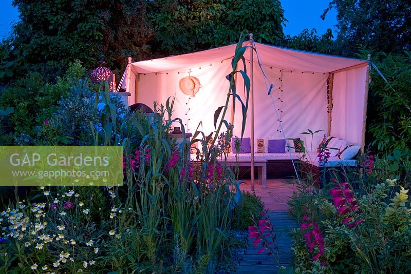 Moroccan inspired garden with drought tolerant planting and Moroccan style tent lit up in the evening