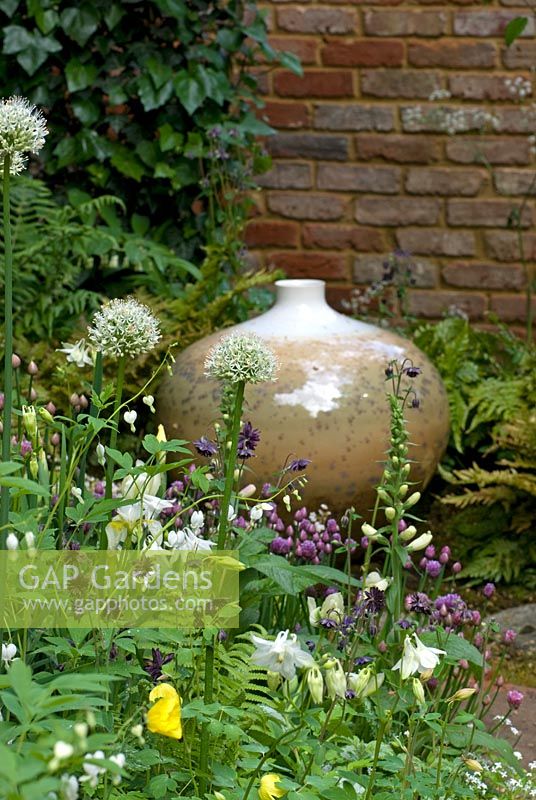Glazed pot by John Stroomer surrounded by Aquilegia vulgaris 'Nivea', Allium 'Mont Blanc', Digitalis, Chives and Dicentra. Pottering in North Cumbria, sponsored by University of Cumbria, Cumbrian Homes Ltd, Copeland Borough Council - Silver Flora medal winner for Courtyard Garden at RHS Chelsea Flower Show 2009