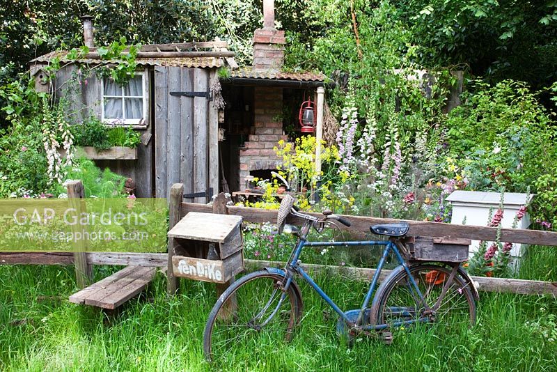 A wooden stile leads into The Fenland Alchemist Garden, sponsored by Giles Landscapes - Gold medal winner for Best Courtyard Garden at RHS Chelsea Flower Show 2009 