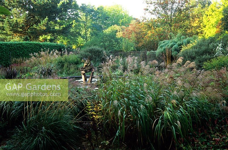 Autumn border of grasses and perennials including Miscanthus, Persicaria and Phormium tenax at Knoll Gardens, Dorset in  October