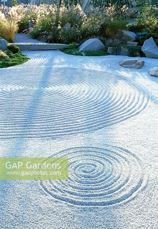 Japanese inspired garden for the offices of a Pharmaceutical company, Boston. Patterns have been raked into the gravel, planted with grasses and stone bridge