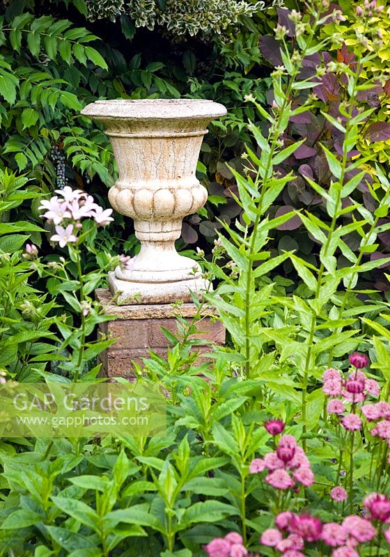 Stone urn on brick plinth in secluded suburban garden with co-ordinated design features and colour themed borders - High Trees, NGS, Longton, Stoke-on-Trent, Staffordshire