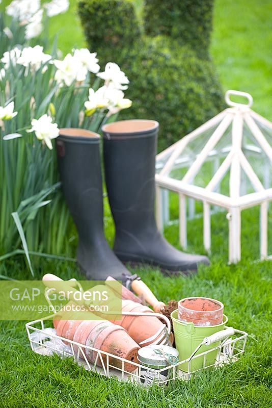 Wellies with a collection of pots in basket and cloche