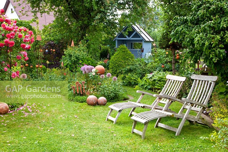 Country House Rose Garden with Rosa 'Rosarium Uetersen' and wooden recliners