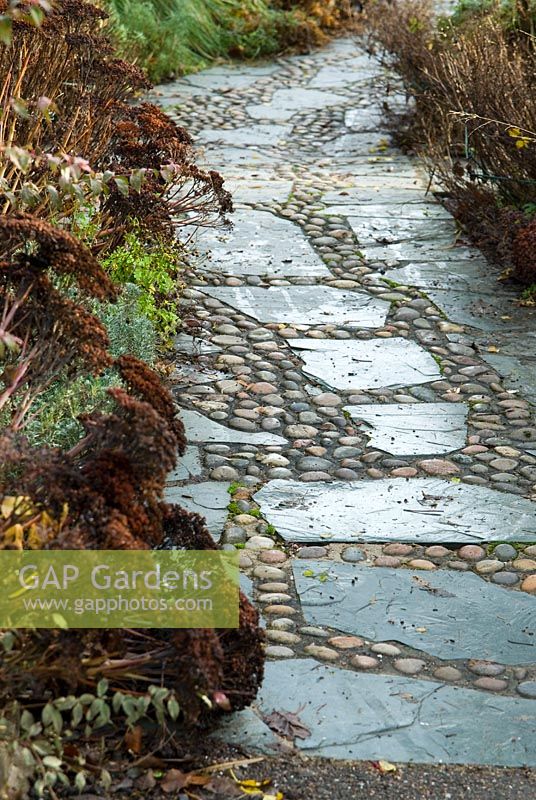 Path of slate and sea washed pebbles in the West Country town garden, one of the model gardens. RHS Garden Rosemoor, Great Torrington, Devon, UK