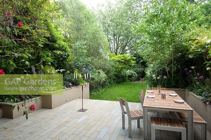 Large urban garden with furniture on patio. The Merrick Garden, London, UK