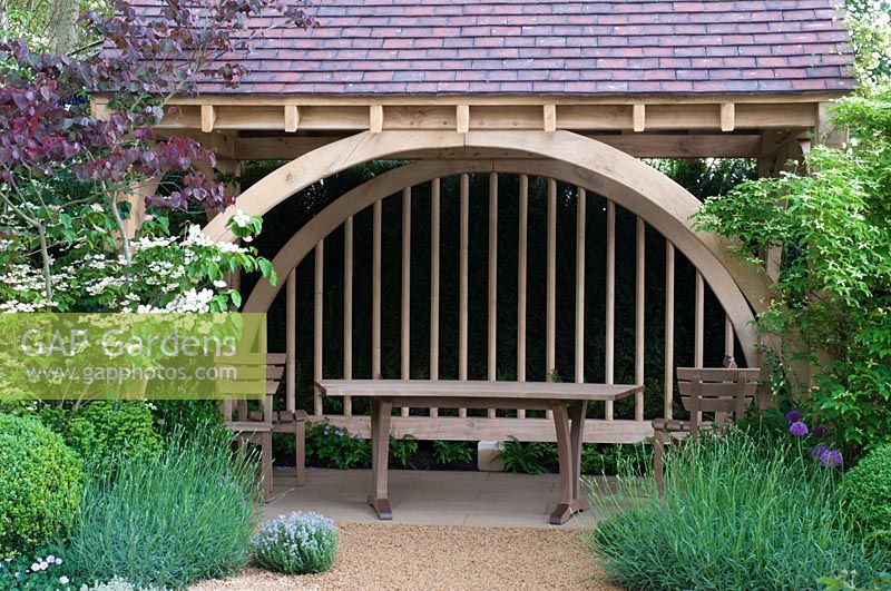 Oak summerhouse with curved oak table and chairs, surrounded by Cornus kousa 'Satomi', Lavandula angustifolia and clipped Buxus in The M&G Garden, Gold medal winner, RHS Chelsea Flower Show 2010 
 
