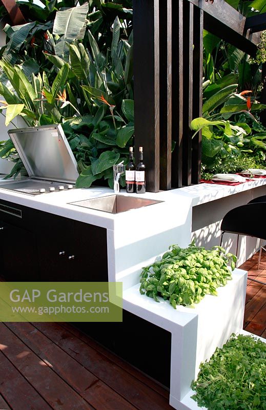 Built in barbecue and entertaining area in tropical garden. Herbs in raised planters. Trailfinders Australian Garden, Gold medal winner, RHS Chelsea Flower Show 2010 