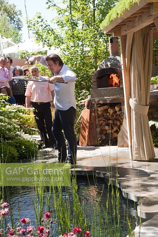 Jamie Oliver cooking. Clay oven next to a plunge pool and covered seating area with green roof. The Children's Society garden, Gold medal winner, RHS Chelsea Flower Show 2010 
 