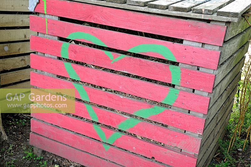 Colourful compost bin with a heart painted on the front