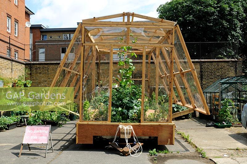 Travelling greenhouse, pulled by people, parked in St Lukes Community Allotments, Clerkenwell, London Borough of Islington UK
